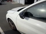 a white car parked in a parking lot next to a building