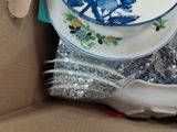 a box full of plates and forks and spoons in it