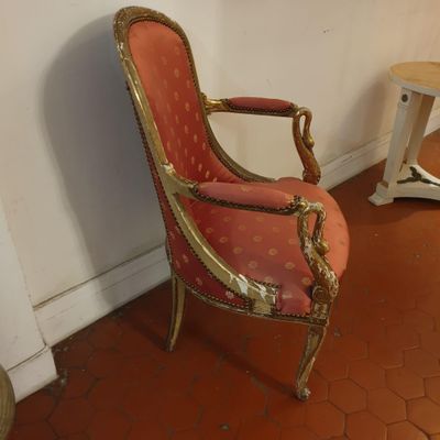 une chaise rouge et dorée dans un coin de la pièce