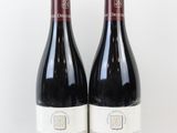 deux bouteilles de vin rouge posées l'une à côté de l'autre sur une surface blanche