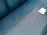 a blue couch with a tag on it in a room