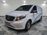 la camionnette blanche est garée dans une grande pièce au sol en damier