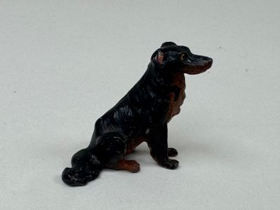 un petit chien en peluche assis sur une surface blanche