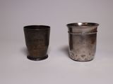 two silver cups sitting next to each other on a table