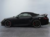the black sports car is parked on the concrete floor in the room