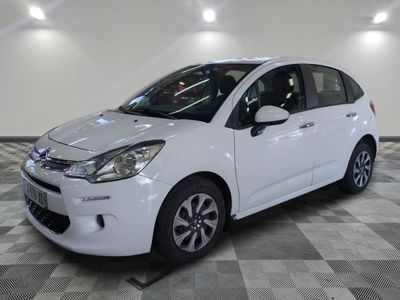 la petite voiture blanche est garée sur un carrelage à carreaux