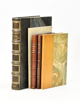 three books sitting next to each other on a white surface