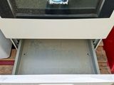 a white oven with a door open on a sidewalk