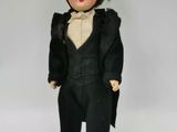une poupée noire portant un haut-de-forme et un costume noir