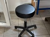 un tabouret noir posé au milieu d'un sol carrelé