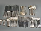 many forks and spoons laid out on the table