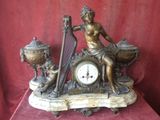 a statue of a woman sitting on a table with a harp