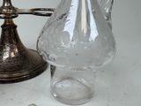 a glass pitcher sitting on a table next to a lamp