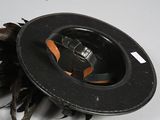 a black hat with a feather on top of it