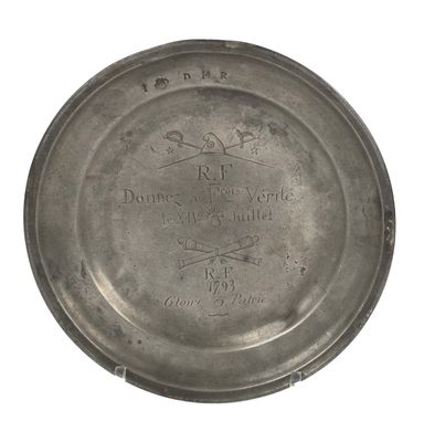 a silver plate with a picture on it on a white background