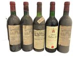 six bouteilles de vin sont alignées sur une surface blanche