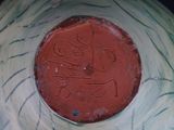a close up of a red and green bowl with writing on it