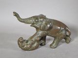 statue of an elephant and a baby elephant on a white surface