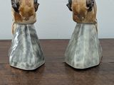 two figurines of animals sitting on a wooden table