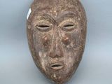 une image représentant un masque en bois sur lequel est peint un visage