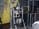 a gym room with equipment in it and a yellow and black wall