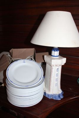 une table sur laquelle se trouvent une lampe, des assiettes et une lampe