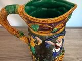 a green and yellow pitcher sitting on a wooden table
