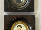 two framed portraits of a man and a woman are on display