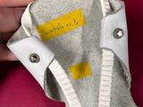 a person holding a pair of shoes with a label on it