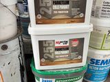 several buckets of paint sitting on top of a wooden pallet