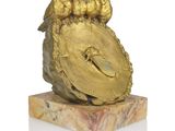 three birds sitting on top of a gold clock on a marble base