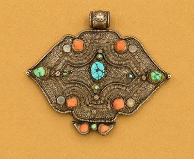 a close up of a silver pendant with a turquoise stone in the center