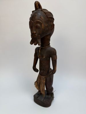 une statue en bois représentant une femme avec un oiseau sur la tête