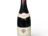 une vieille bouteille de vin posée sur une surface blanche