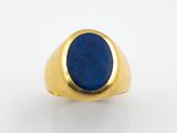 un gros plan d'une bague en or sertie d'un lapis-lazuli