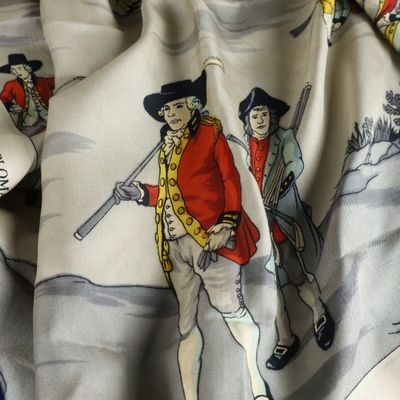 a close up of a scarf with a picture of a man holding a gun