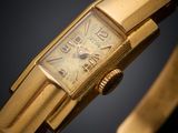an image of a gold wrist watch on a black background