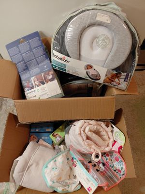 une boîte remplie de couches et d'autres articles pour bébé posée par terre