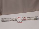 an old baseball bat sitting on top of a table next to a roll of paper