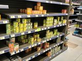 many shelves in the store with canned food on them