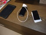 two cell phones and a charger sitting on a table