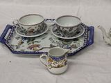a tray with a tea set on it and a tray with cups and saucers