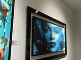 two paintings on the wall of a room with a tv