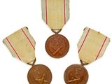 trois médailles avec leurs rubans et une médaille sur fond blanc