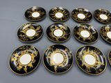 six assiettes noires et dorées ornées de motifs dorés