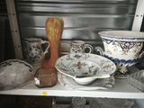 a shelf that has many different types of vases and dishes on it