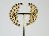 a close up of a gold and silver beaded brooch