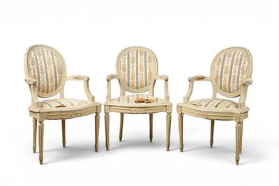 trois chaises blanches avec des accoudoirs rembourrés à rayures et des pieds