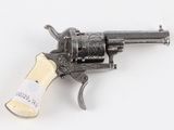 an old gun with a tag on it sitting on a white surface