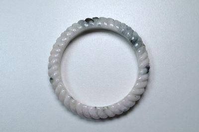 un bracelet blanc orné d'une perle noire